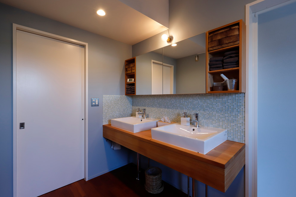 Idéer för ett rustikt brun toalett, med öppna hyllor, skåp i mörkt trä, blå kakel, mosaik, grå väggar, mörkt trägolv, ett fristående handfat, träbänkskiva och brunt golv