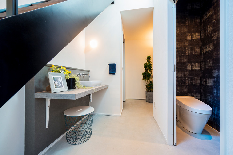 На фото: туалет в стиле модернизм с белыми стенами, настольной раковиной и серым полом с