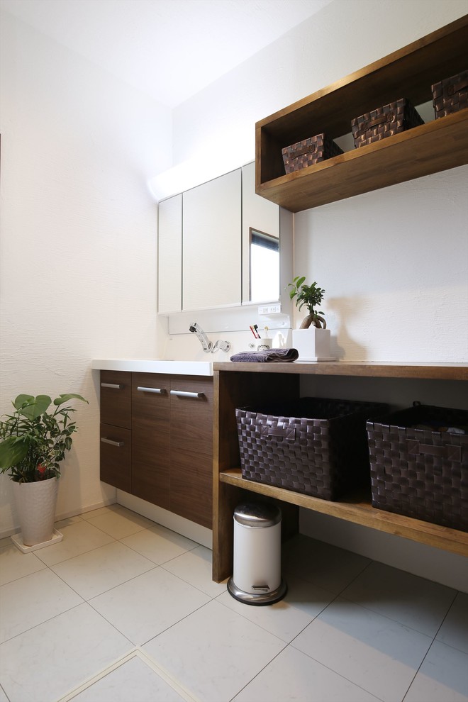 На фото: туалет в скандинавском стиле с открытыми фасадами, темными деревянными фасадами, монолитной раковиной и белым полом