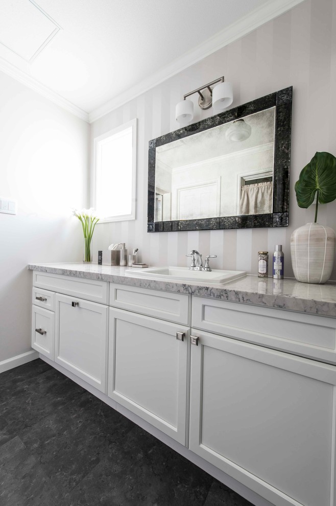 他の地域にあるトランジショナルスタイルのおしゃれなトイレ・洗面所 (白いキャビネット、オーバーカウンターシンク、大理石の洗面台、白い壁、黒い床) の写真