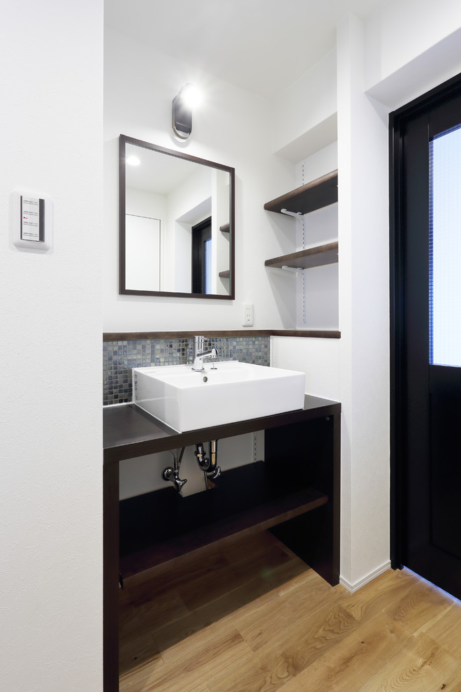 Inspiration for a small scandinavian cloakroom in Tokyo with open cabinets, dark wood cabinets, multi-coloured tiles, mosaic tiles, white walls, light hardwood flooring, a vessel sink, wooden worktops, brown floors and brown worktops.