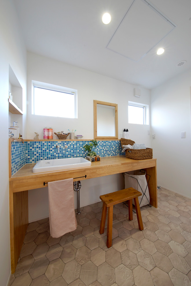 他の地域にある北欧スタイルのおしゃれなトイレ・洗面所 (白い壁、オーバーカウンターシンク、茶色い床) の写真