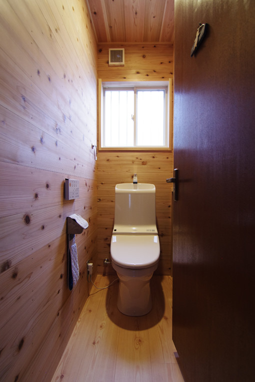 Ejemplo de aseo moderno con sanitario de una pieza, paredes beige y suelo de madera clara