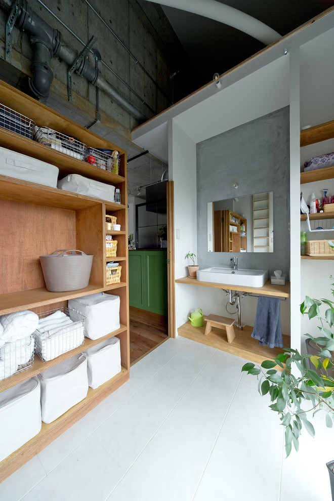 大阪にあるインダストリアルスタイルのおしゃれなトイレ・洗面所 (オープンシェルフ、グレーの壁、ベッセル式洗面器、グレーの床) の写真