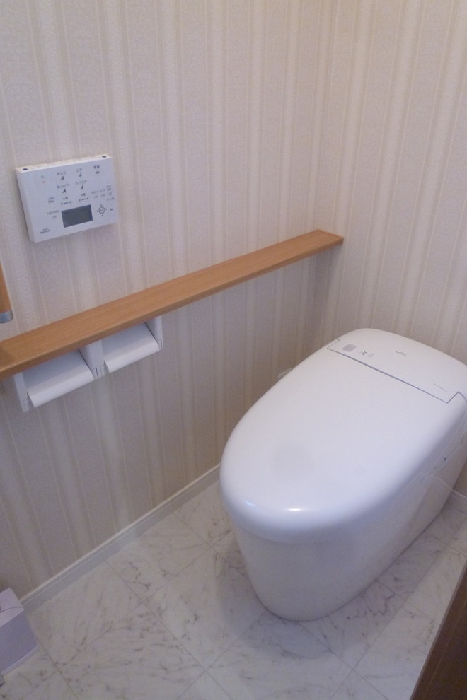 Exempel på ett litet shabby chic-inspirerat toalett, med släta luckor, skåp i mellenmörkt trä, en toalettstol med hel cisternkåpa, beige väggar, vinylgolv och ett fristående handfat