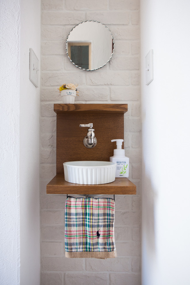 他の地域にある小さなコンテンポラリースタイルのおしゃれなトイレ・洗面所 (ベッセル式洗面器、木製洗面台、ブラウンの洗面カウンター) の写真