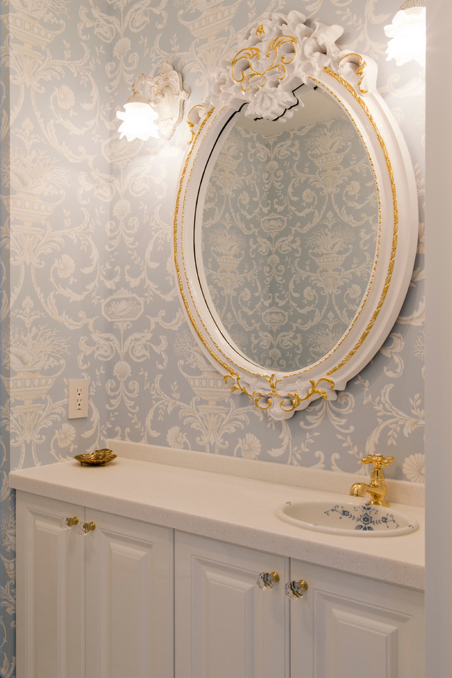 Immagine di un piccolo bagno di servizio vittoriano con ante con bugna sagomata, ante bianche, pareti blu e lavabo da incasso