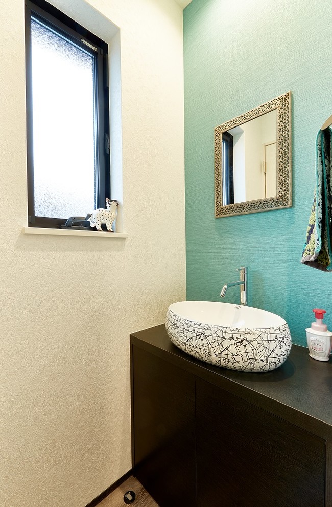 Пример оригинального дизайна: туалет в стиле модернизм с плоскими фасадами, темными деревянными фасадами, синими стенами, полом из фанеры и коричневым полом