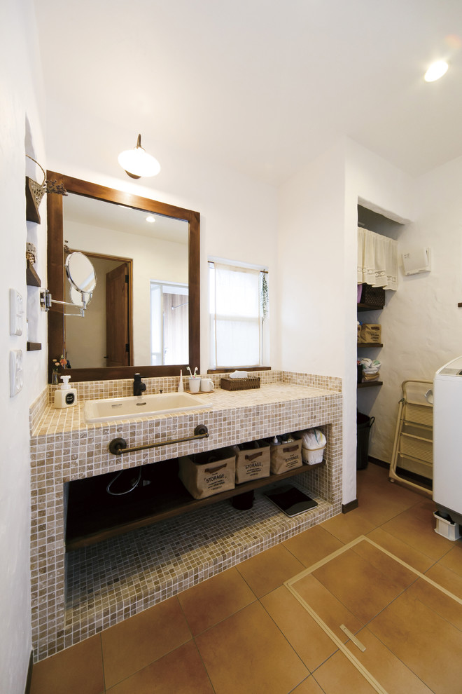 他の地域にあるアジアンスタイルのおしゃれなトイレ・洗面所 (オープンシェルフ、白い壁、無垢フローリング、オーバーカウンターシンク、茶色い床) の写真