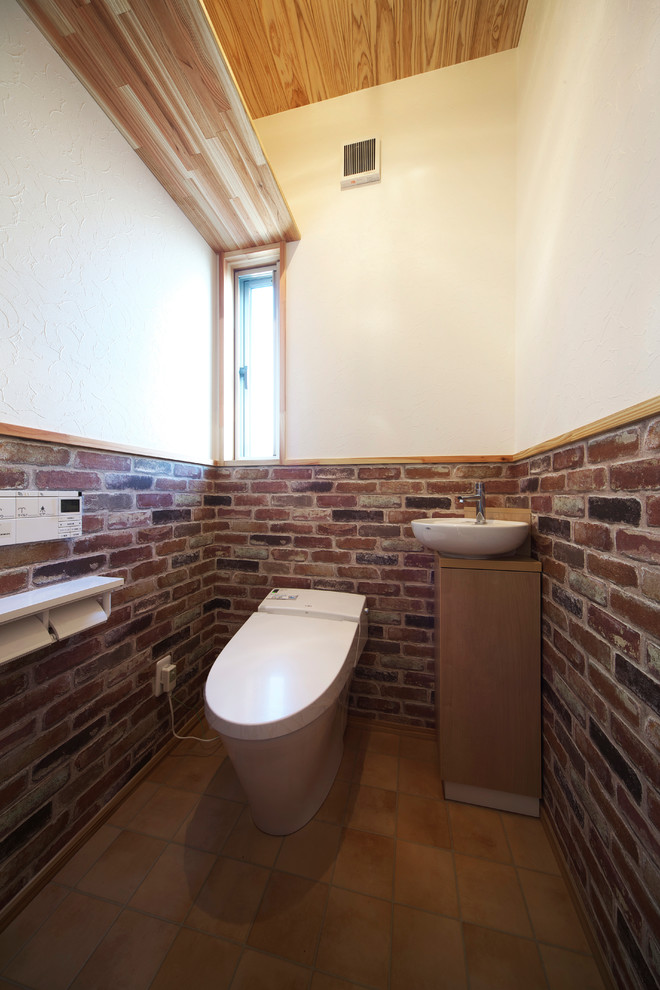 他の地域にあるインダストリアルスタイルのおしゃれなトイレ・洗面所 (白い壁、茶色い床) の写真