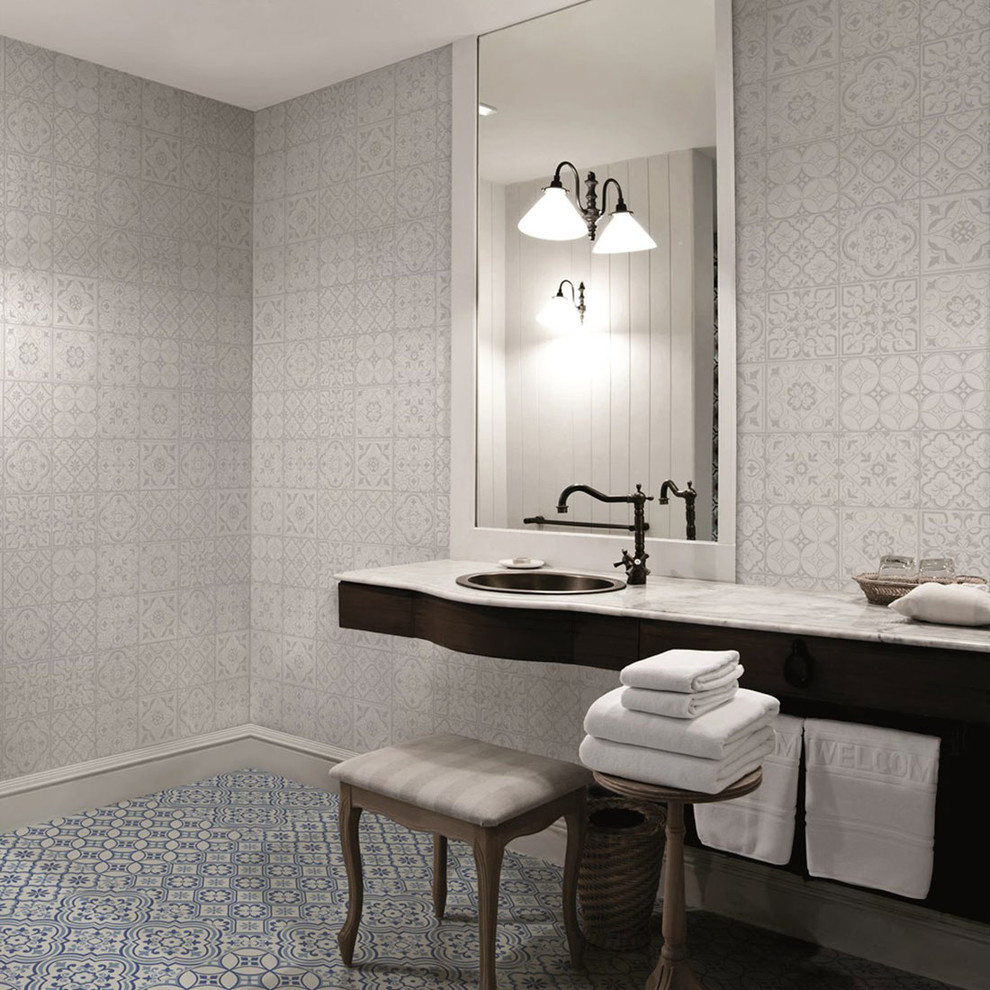 他の地域にあるトラディショナルスタイルのおしゃれなトイレ・洗面所 (グレーのタイル、青いタイル、マルチカラーの壁、オーバーカウンターシンク、マルチカラーの床) の写真