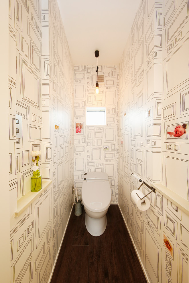 Esempio di un bagno di servizio contemporaneo con WC monopezzo, pareti bianche, parquet scuro e pavimento marrone