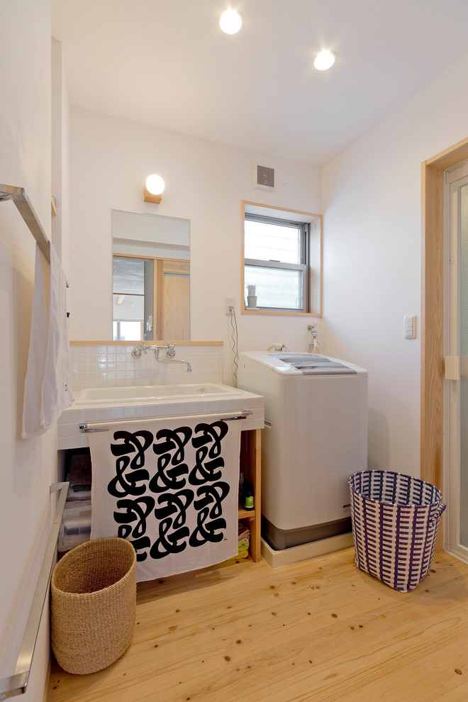 他の地域にあるアジアンスタイルのおしゃれなトイレ・洗面所 (オープンシェルフ、白い壁、淡色無垢フローリング、オーバーカウンターシンク、茶色い床) の写真