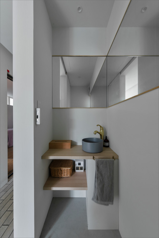 Aménagement d'un WC et toilettes scandinave en bois clair de taille moyenne avec un placard à porte affleurante, un carrelage blanc, mosaïque, un mur blanc, un sol en bois brun, un lavabo posé, un plan de toilette en béton, un sol beige et un plan de toilette gris.