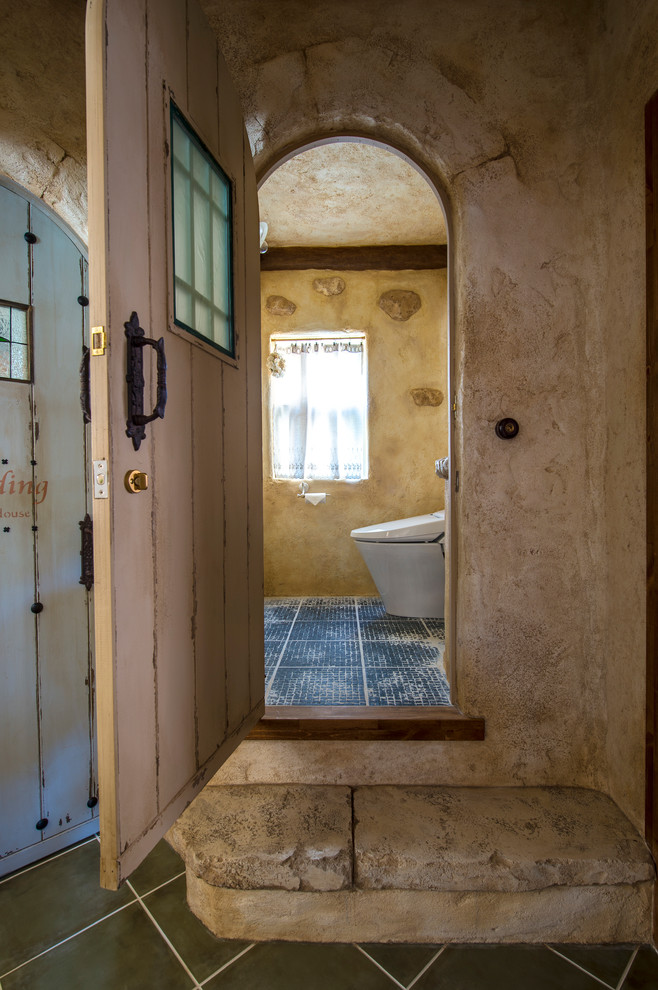 Источник вдохновения для домашнего уюта: туалет в средиземноморском стиле с бежевыми стенами и черным полом