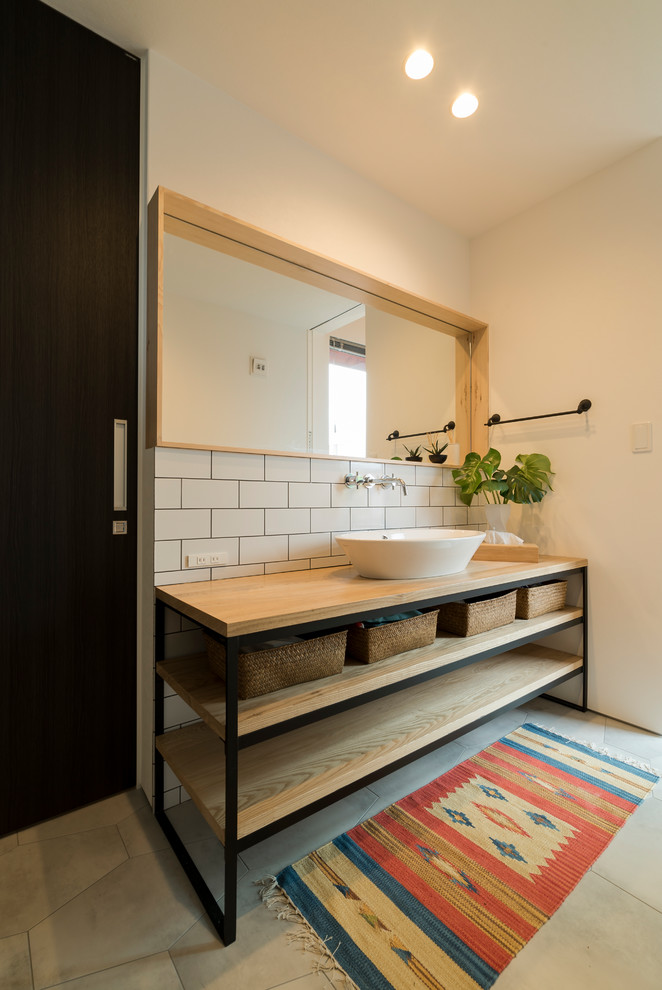 Skandinavische Gästetoilette mit offenen Schränken, weißer Wandfarbe, Betonboden, Aufsatzwaschbecken, Waschtisch aus Holz und grauem Boden in Sonstige