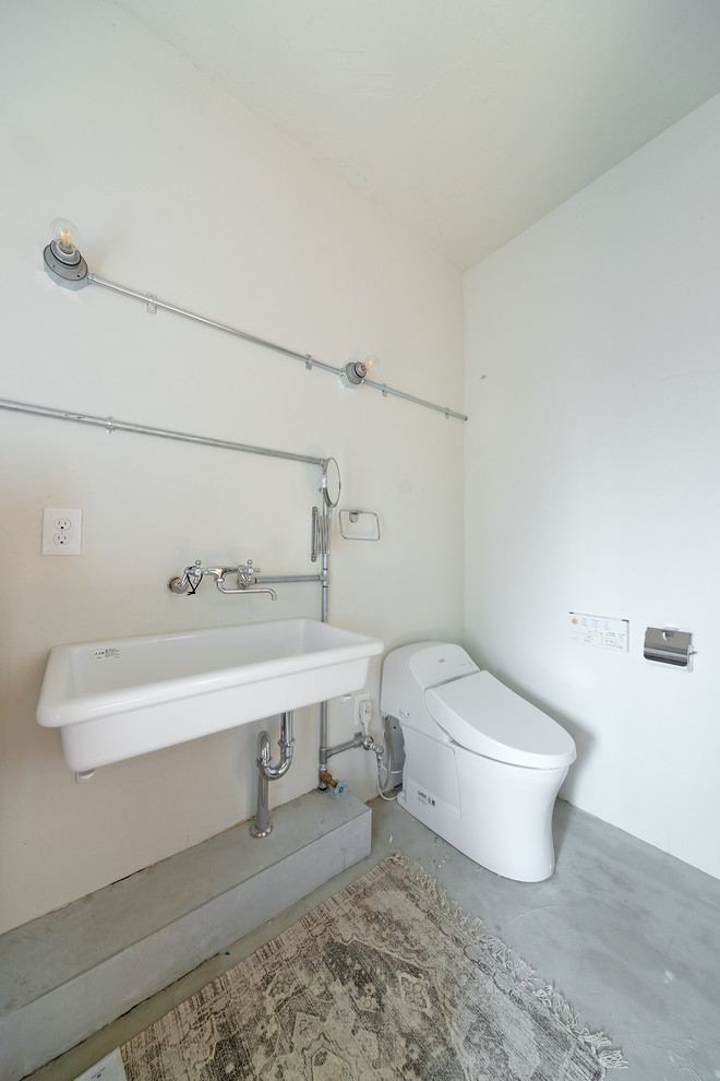 大阪にある中くらいなインダストリアルスタイルのおしゃれなトイレ・洗面所 (一体型トイレ	、青い壁、モザイクタイル、ペデスタルシンク、白い床、白い洗面カウンター) の写真
