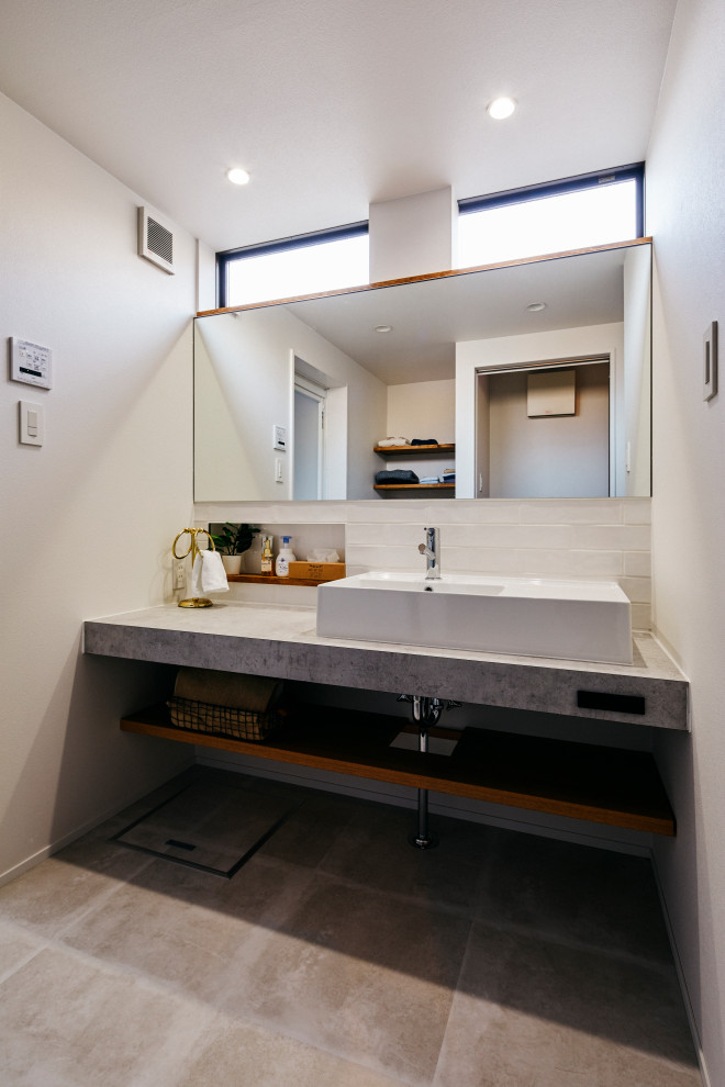 Идея дизайна: туалет среднего размера с серыми фасадами, белой плиткой, белыми стенами, столешницей из плитки, серым полом, белой столешницей и встроенной тумбой