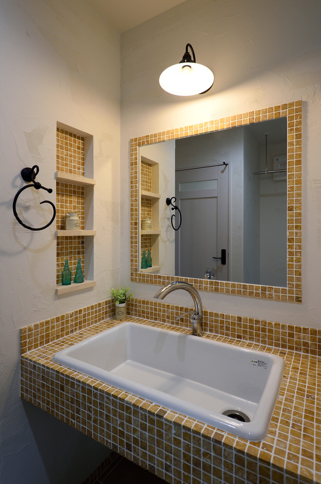 他の地域にある地中海スタイルのおしゃれなトイレ・洗面所 (白い壁、オーバーカウンターシンク) の写真