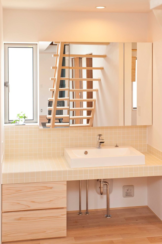 他の地域にあるモダンスタイルのおしゃれなトイレ・洗面所 (白い壁、無垢フローリング、ベッセル式洗面器、茶色い床) の写真