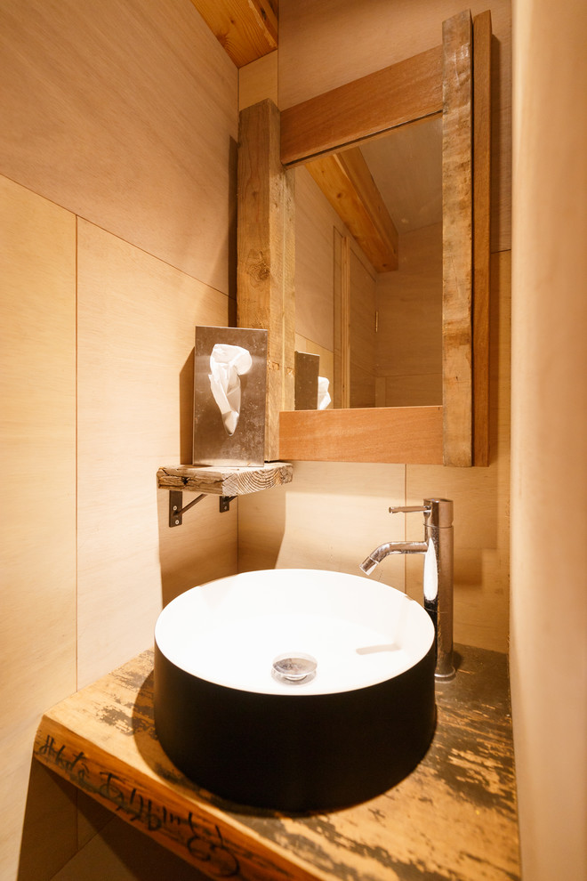 他の地域にあるモダンスタイルのおしゃれなトイレ・洗面所 (茶色い壁、ベッセル式洗面器、木製洗面台、ブラウンの洗面カウンター) の写真