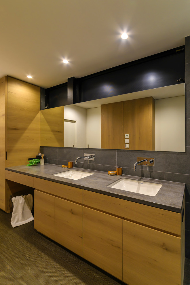 На фото: туалет с плоскими фасадами, фасадами цвета дерева среднего тона и серыми стенами