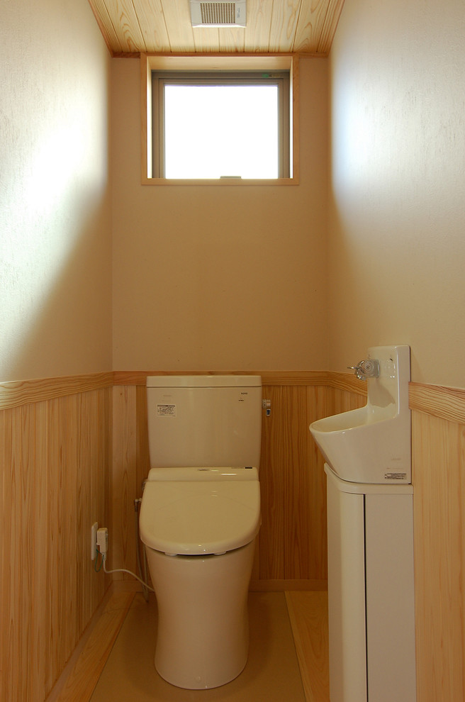 Стильный дизайн: туалет в восточном стиле с унитазом-моноблоком, бежевыми стенами, полом из керамической плитки и бежевым полом - последний тренд