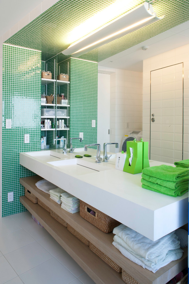 Пример оригинального дизайна: туалет в современном стиле с монолитной раковиной, открытыми фасадами, светлыми деревянными фасадами, зеленой плиткой, плиткой мозаикой, разноцветными стенами и белой столешницей