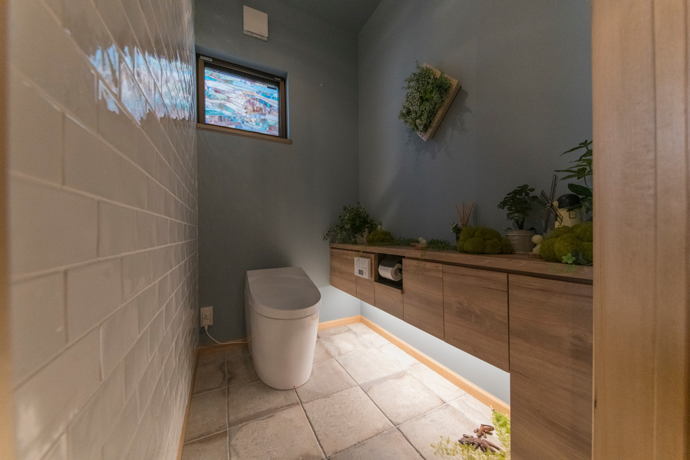 На фото: туалет в классическом стиле с открытыми фасадами, темными деревянными фасадами, белой плиткой, керамогранитной плиткой, синими стенами, полом из керамогранита, серым полом и коричневой столешницей с