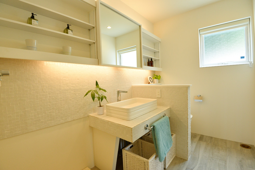 Photo of a scandinavian cloakroom in Other with white walls, a vessel sink and beige floors.