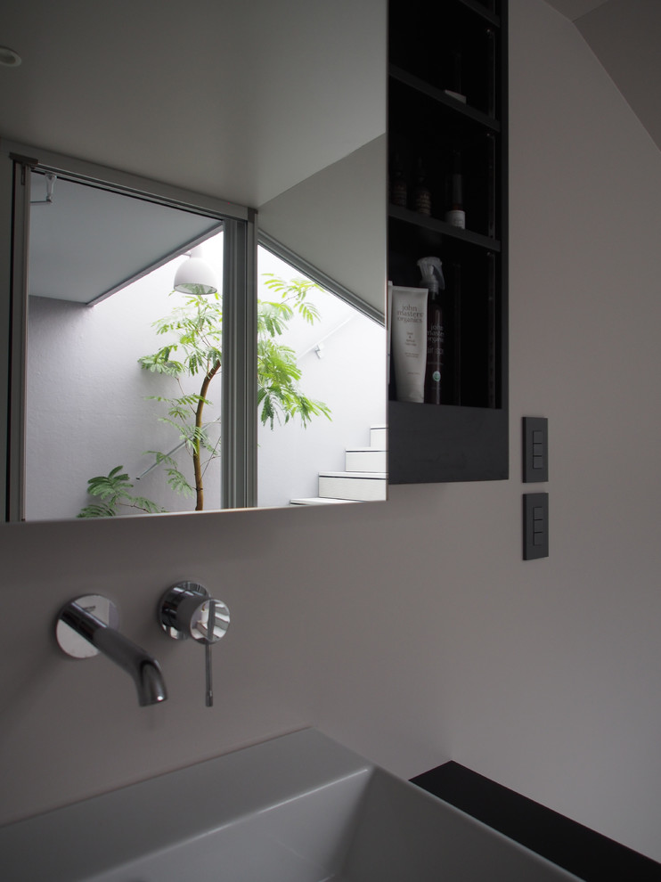 Свежая идея для дизайна: туалет в стиле модернизм с плоскими фасадами, черными фасадами, унитазом-моноблоком, серыми стенами, полом из керамической плитки, настольной раковиной, столешницей из искусственного камня, серым полом и черной столешницей - отличное фото интерьера
