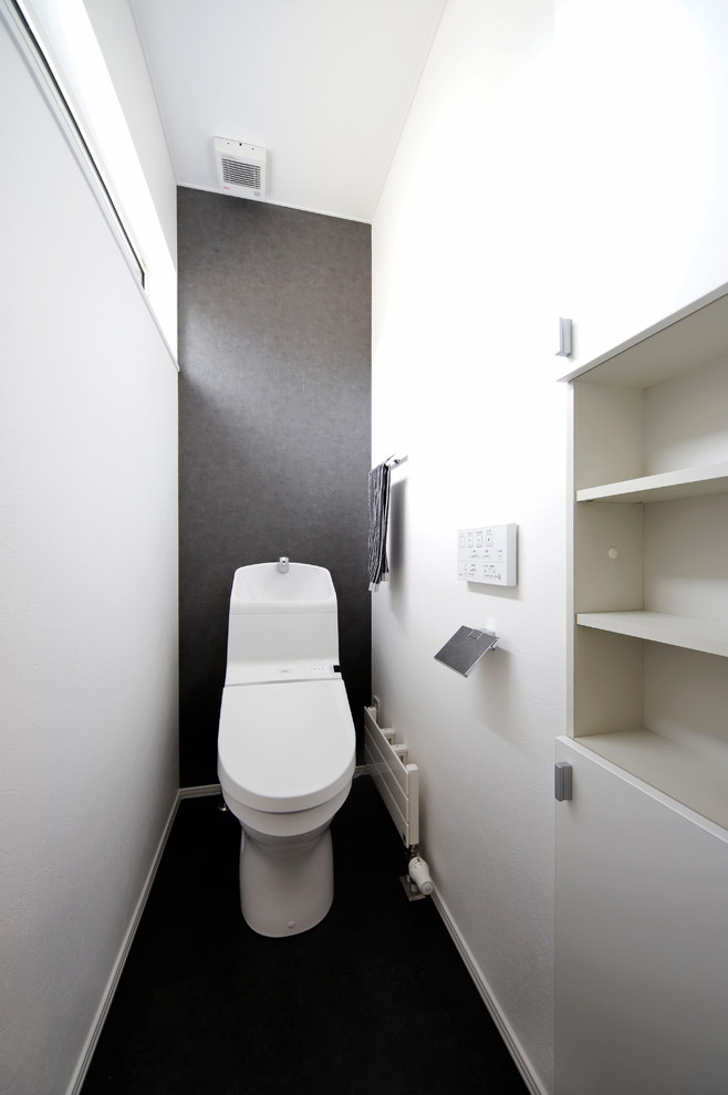札幌にあるアジアンスタイルのおしゃれなトイレ・洗面所 (黒い床) の写真