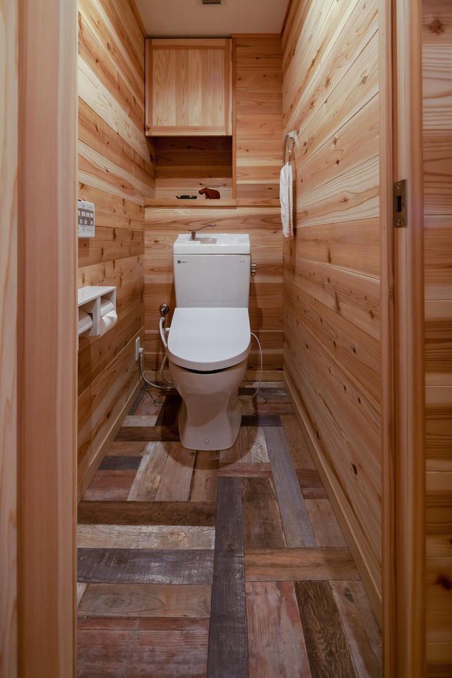 他の地域にあるカントリー風のおしゃれなトイレ・洗面所 (ベージュの壁、無垢フローリング、茶色い床) の写真