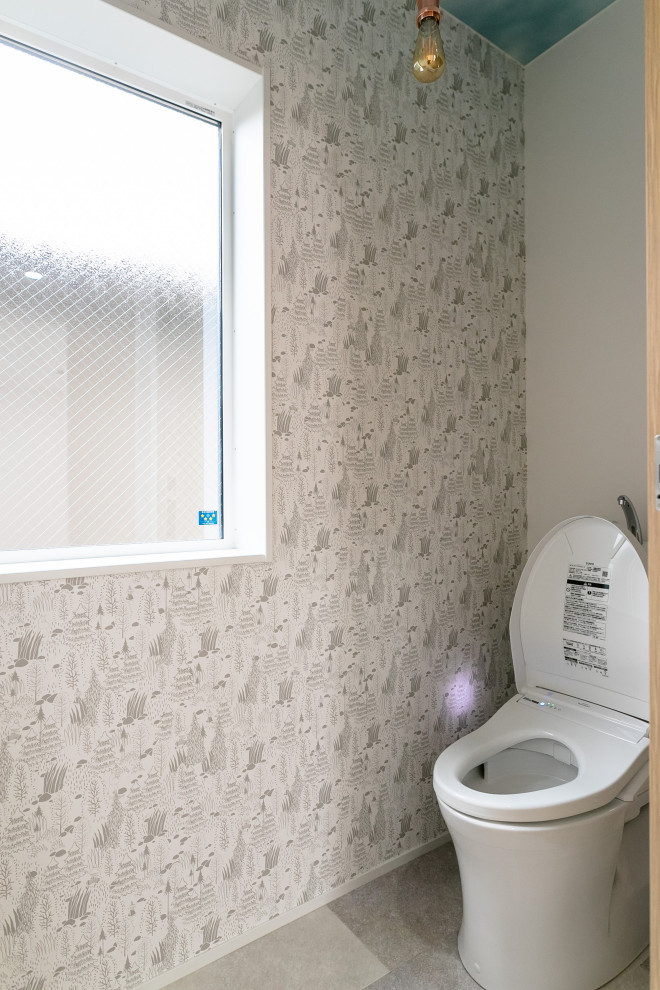 Aménagement d'un WC et toilettes contemporain de taille moyenne avec WC à poser et un mur gris.