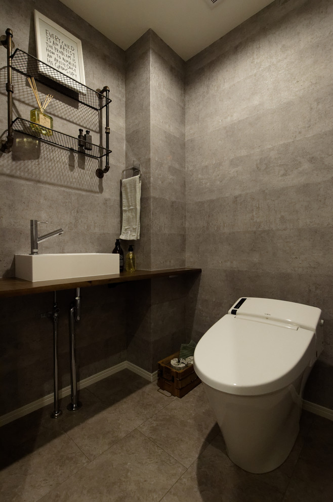 Imagen de aseo industrial con paredes grises, lavabo sobreencimera y suelo gris