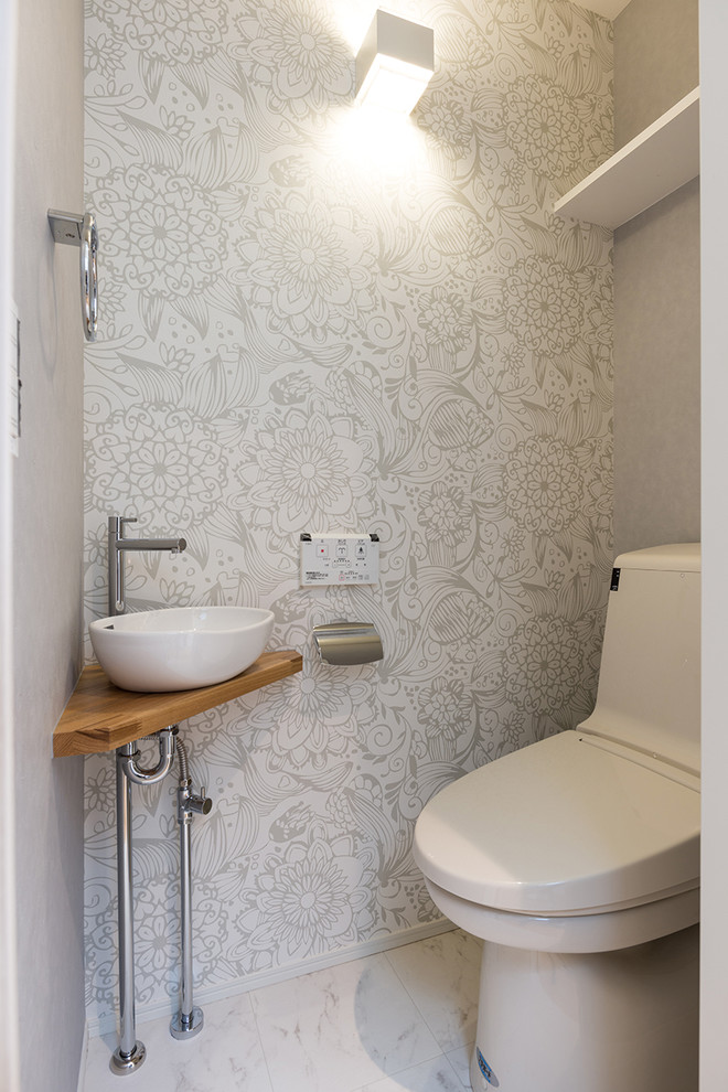 Réalisation d'un WC et toilettes design avec WC à poser, un mur gris, un sol en contreplaqué, un plan vasque et un sol blanc.