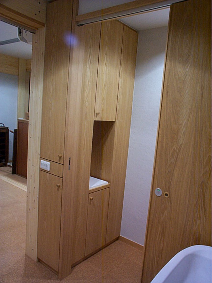 Exempel på ett litet modernt toalett, med vita skåp, en toalettstol med hel cisternkåpa, grå kakel, grå väggar, korkgolv, ett väggmonterat handfat, bänkskiva i onyx och brunt golv