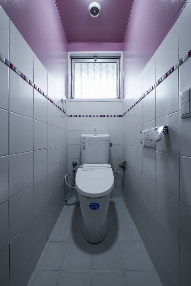 Exempel på ett modernt toalett, med flerfärgade väggar och vitt golv