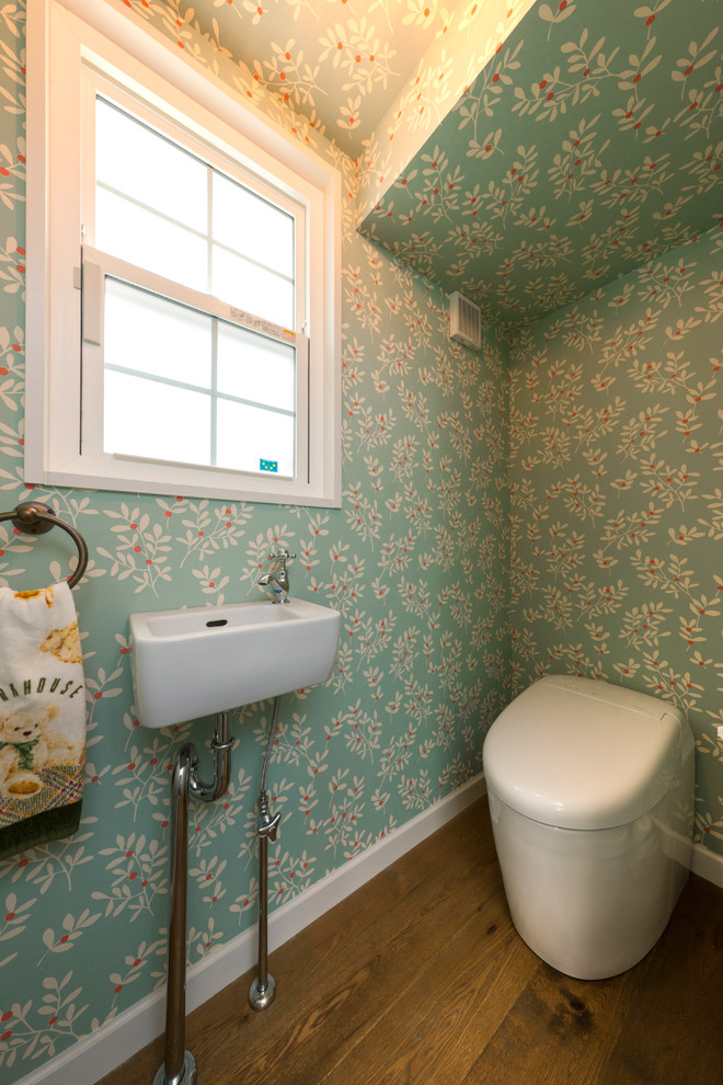 Idées déco pour un WC et toilettes classique avec un mur bleu, parquet foncé, un plan vasque et un sol marron.
