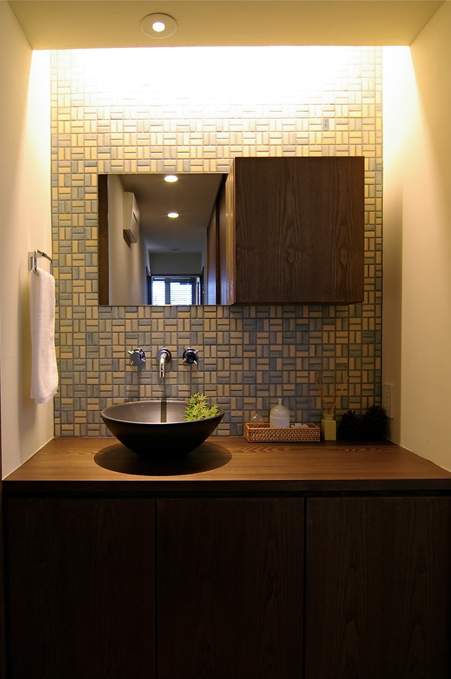 Esempio di un bagno di servizio minimalista con ante lisce, ante in legno scuro, pareti bianche, lavabo a bacinella, top in legno e top marrone