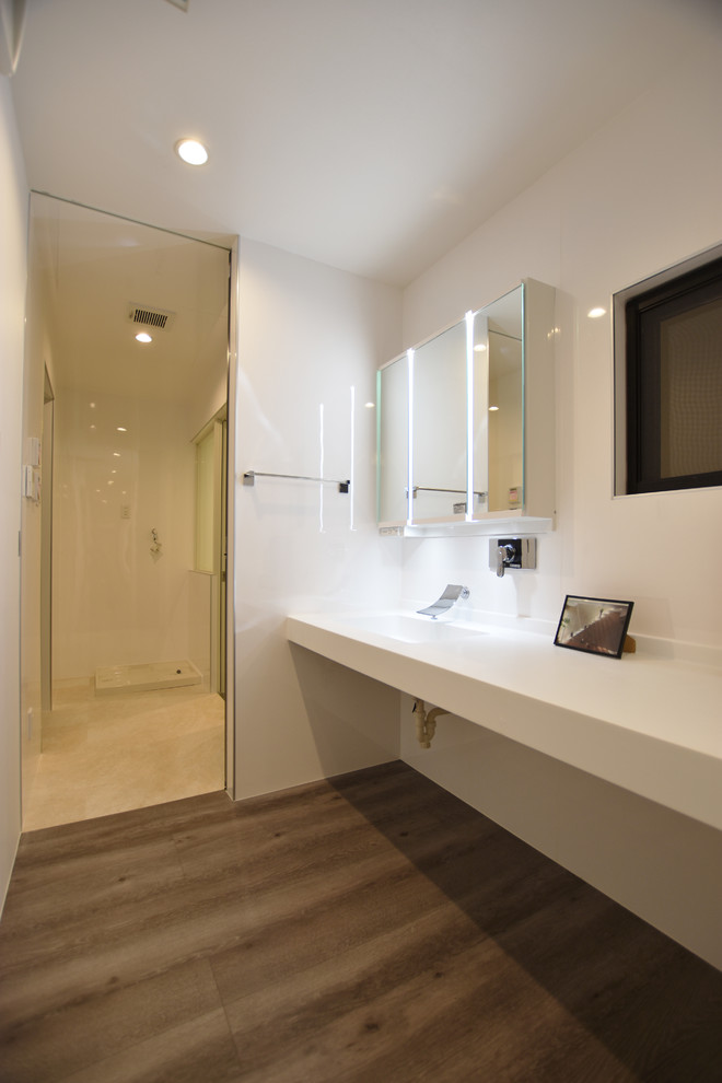 На фото: туалет в стиле модернизм с белыми стенами, полом из фанеры, столешницей из искусственного камня, серым полом и белой столешницей