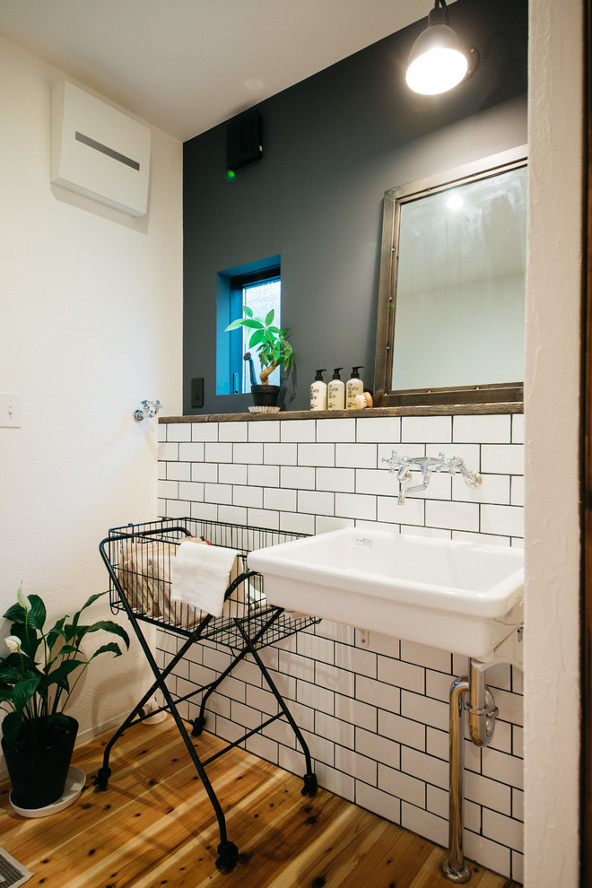 Idee per un bagno di servizio minimalista con pareti multicolore, pavimento in legno massello medio, lavabo sospeso e pavimento marrone