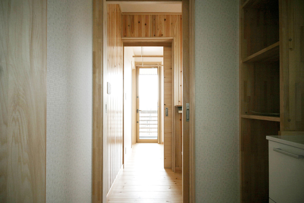 Modelo de aseo asiático grande con puertas de armario blancas, paredes beige, suelo de madera clara, suelo beige y encimeras blancas