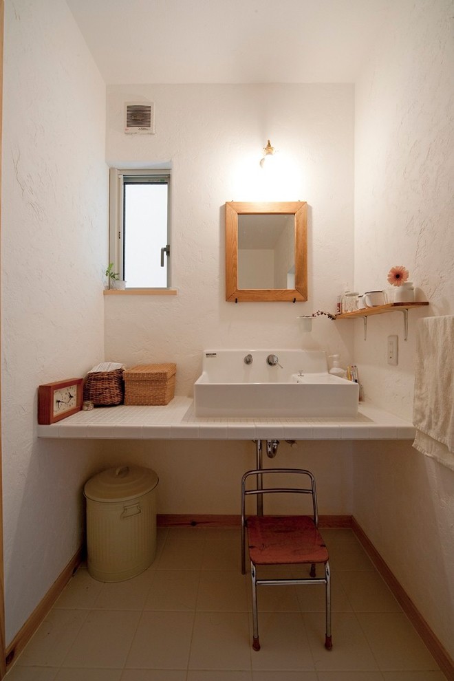 他の地域にあるカントリー風のおしゃれなトイレ・洗面所 (白い壁、オーバーカウンターシンク) の写真