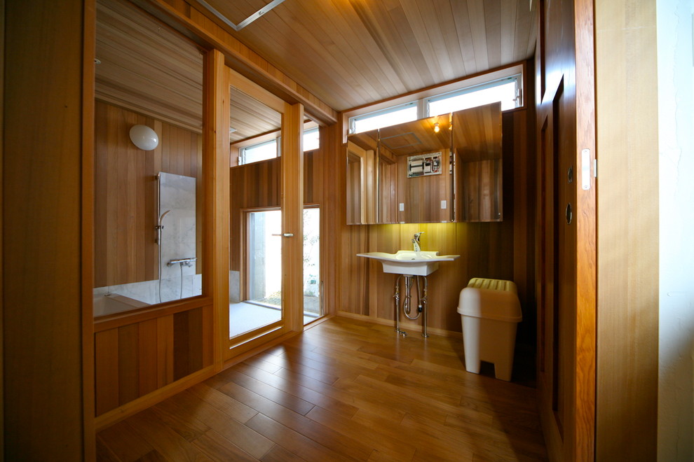 Aménagement d'un WC et toilettes scandinave de taille moyenne avec un mur marron, un sol en bois brun et un sol beige.
