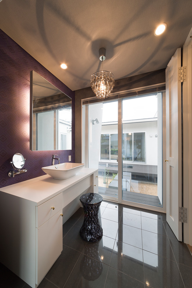他の地域にあるエクレクティックスタイルのおしゃれなトイレ・洗面所 (白いキャビネット、ベッセル式洗面器、紫の壁、フラットパネル扉のキャビネット、グレーのタイル、セラミックタイルの床) の写真