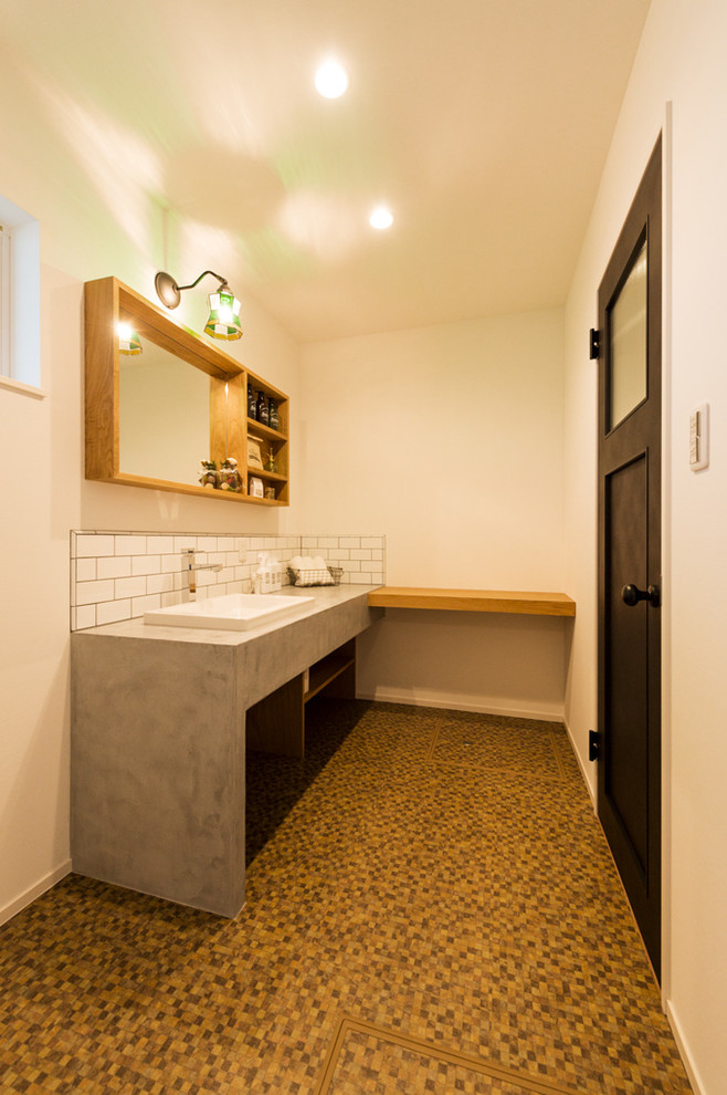 他の地域にある小さなインダストリアルスタイルのおしゃれなトイレ・洗面所 (オープンシェルフ、中間色木目調キャビネット、白いタイル、磁器タイル、白い壁、オーバーカウンターシンク、グレーの洗面カウンター) の写真