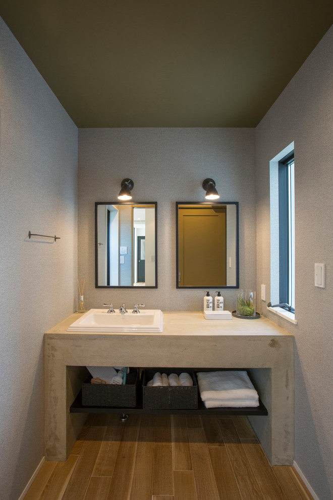 Свежая идея для дизайна: туалет в стиле лофт с открытыми фасадами, серыми стенами, паркетным полом среднего тона, накладной раковиной и коричневым полом - отличное фото интерьера