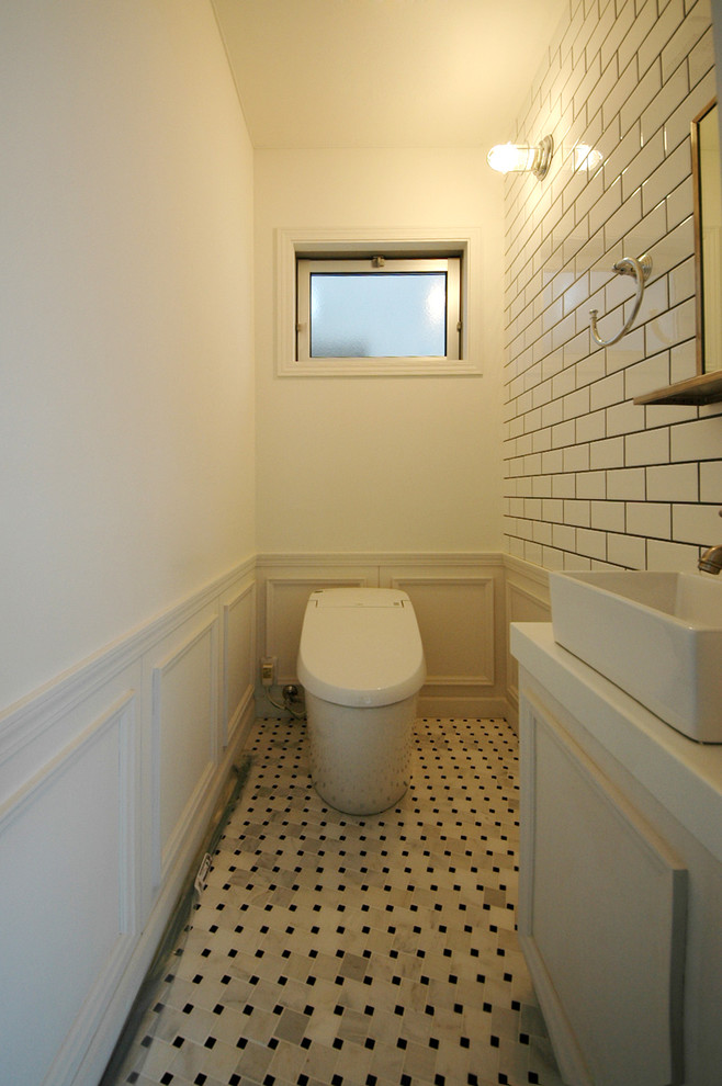 他の地域にあるトランジショナルスタイルのおしゃれなトイレ・洗面所 (マルチカラーの床) の写真
