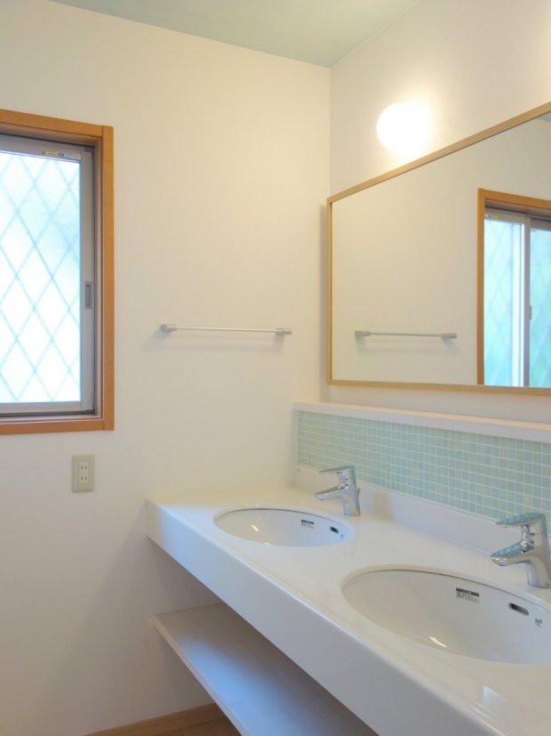 Medium sized scandi cloakroom with open cabinets, light wood cabinets, green tiles, porcelain tiles, white walls, plywood flooring, solid surface worktops, brown floors and a submerged sink.